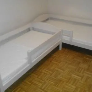 dwa białe łóżka dziecięce